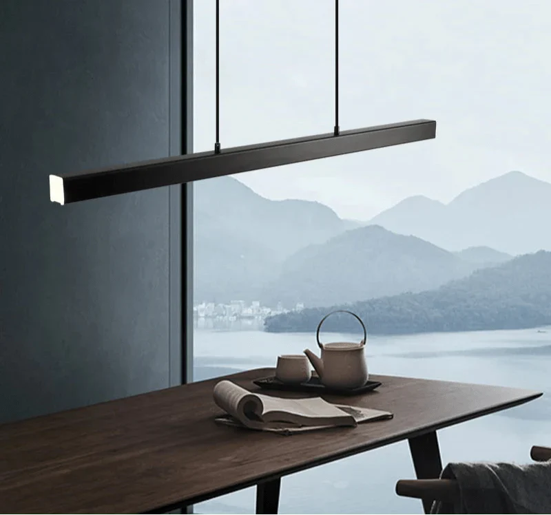 Minimal suspended LED pendant light over a kitchen table with scenic mountain view.