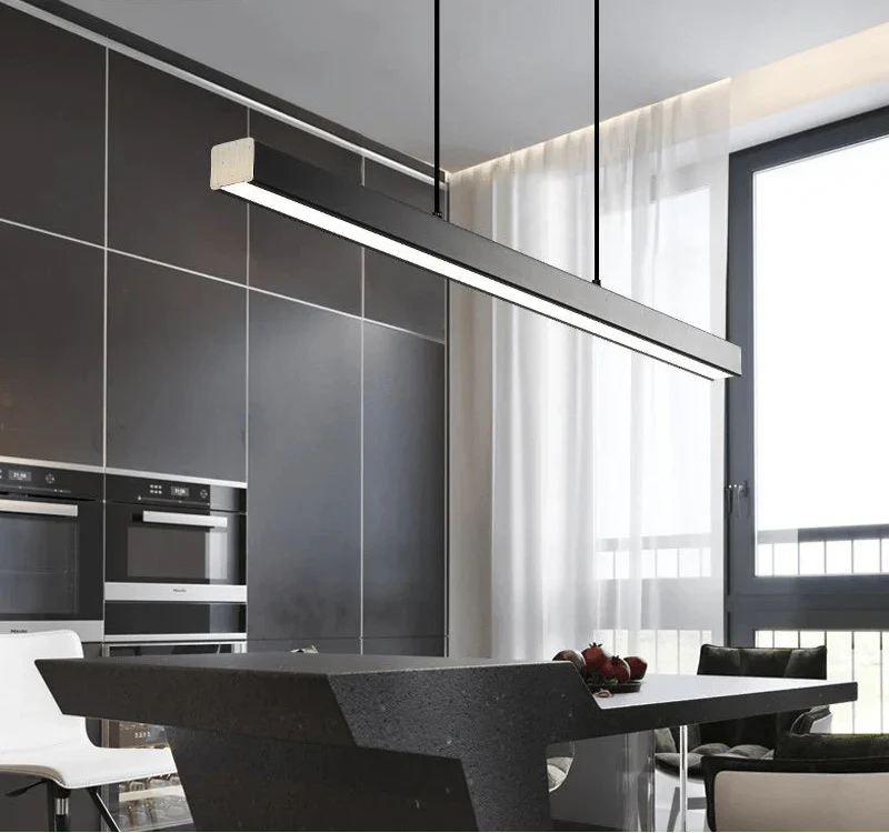 Minimalist black pendant LED light suspended over a modern kitchen island.