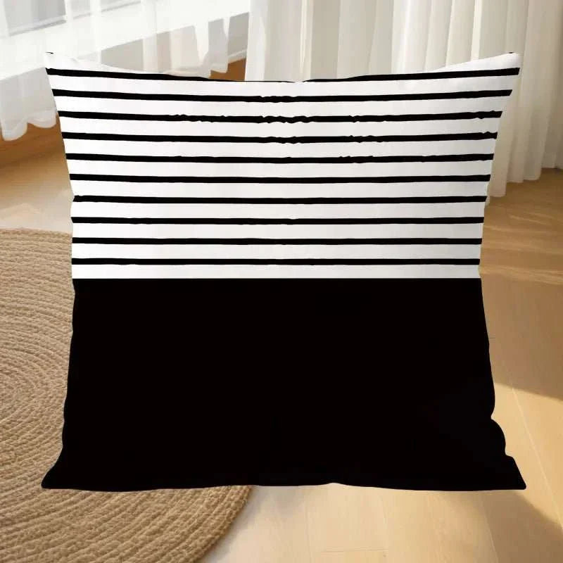 Geometric black and white MIRA™ pillowcase on sofa.