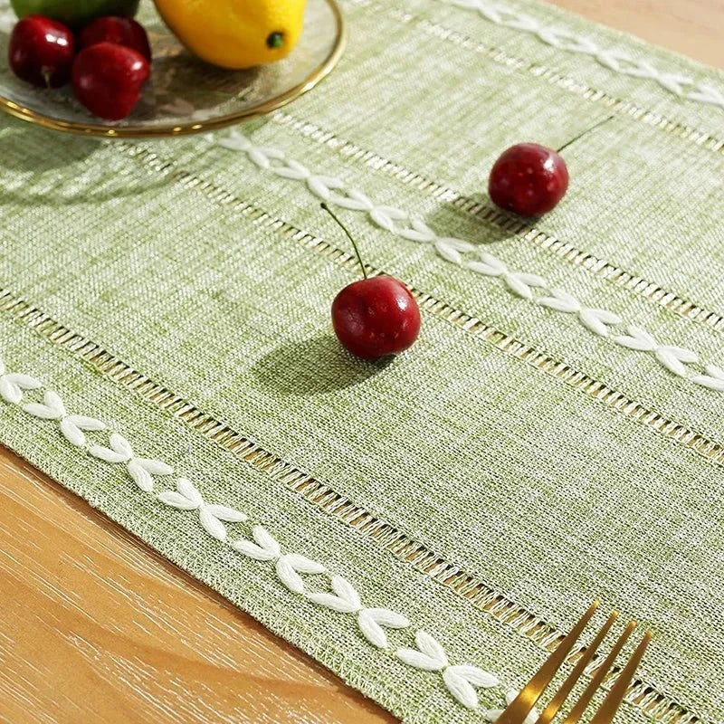 Woven natural cotton table runner with rustic design and embroidery detailing on dining table.
