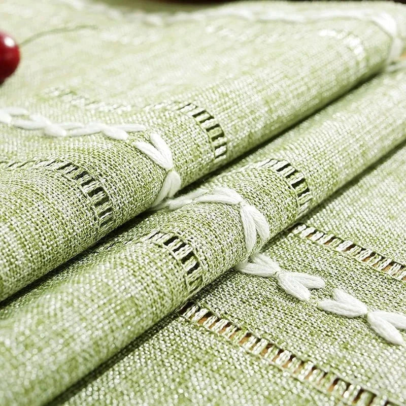 Woven natural cotton table runner with macrame embroidery in rustic farmhouse design.