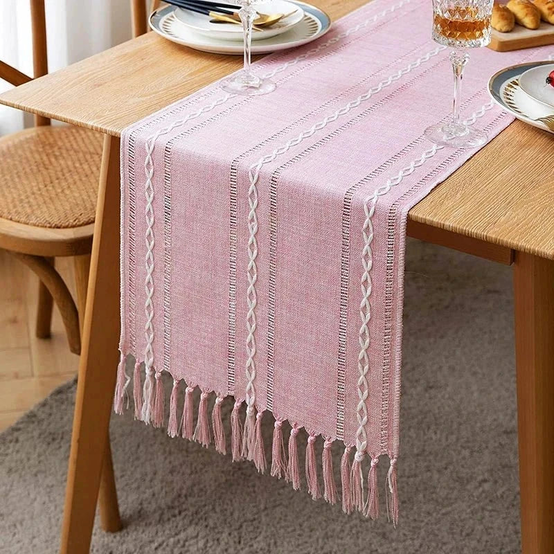 Woven natural cotton table runner with macrame embroidery on dining table.