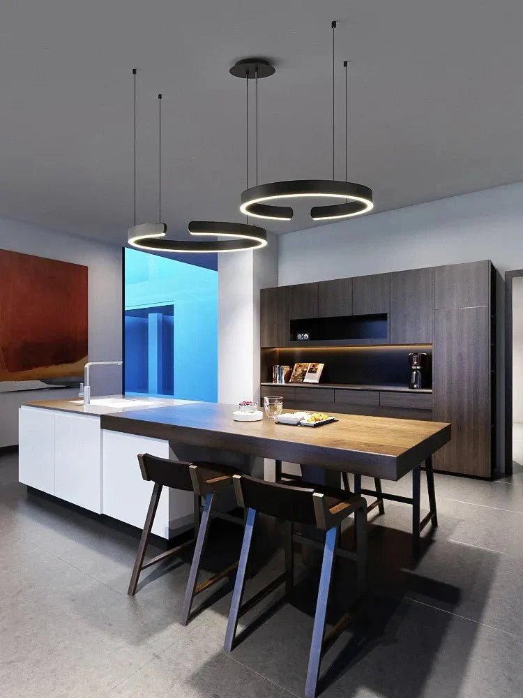 Minimalist geometric LED pendant light in modern kitchen setting.