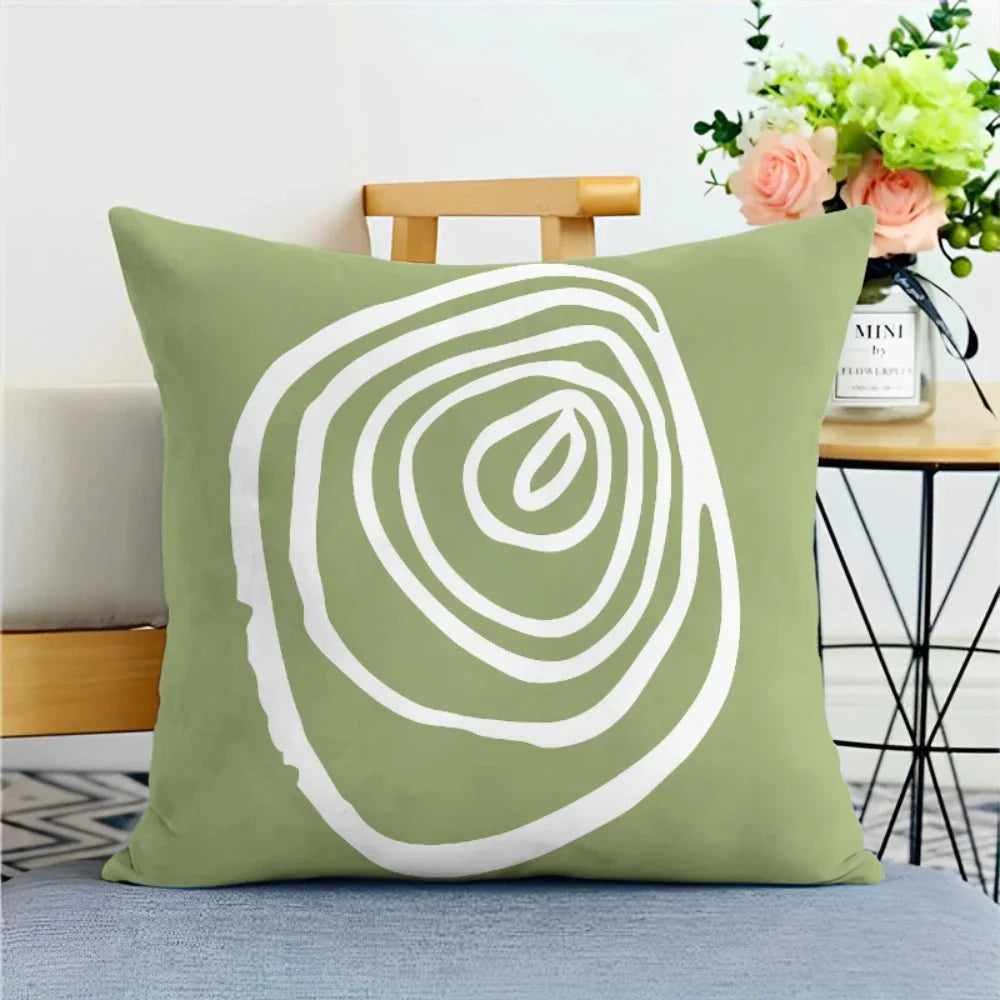 Green nature print pillowcase with abstract design on a sofa.