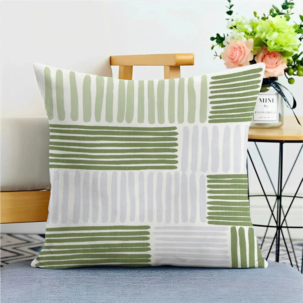 Green nature print pillowcase with sage tones on a cushion in living room setting.