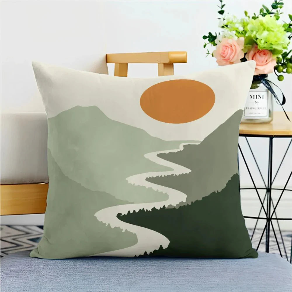 Green nature print pillowcase with abstract mountain and sun design on a chair.