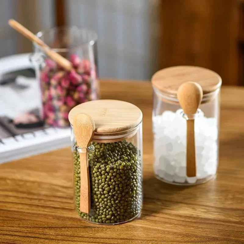 Airtight glass spice jars with bamboo lids and spoons for kitchen storage.