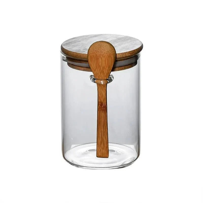 Airtight glass spice jar with bamboo lid and spoon for spice storage.