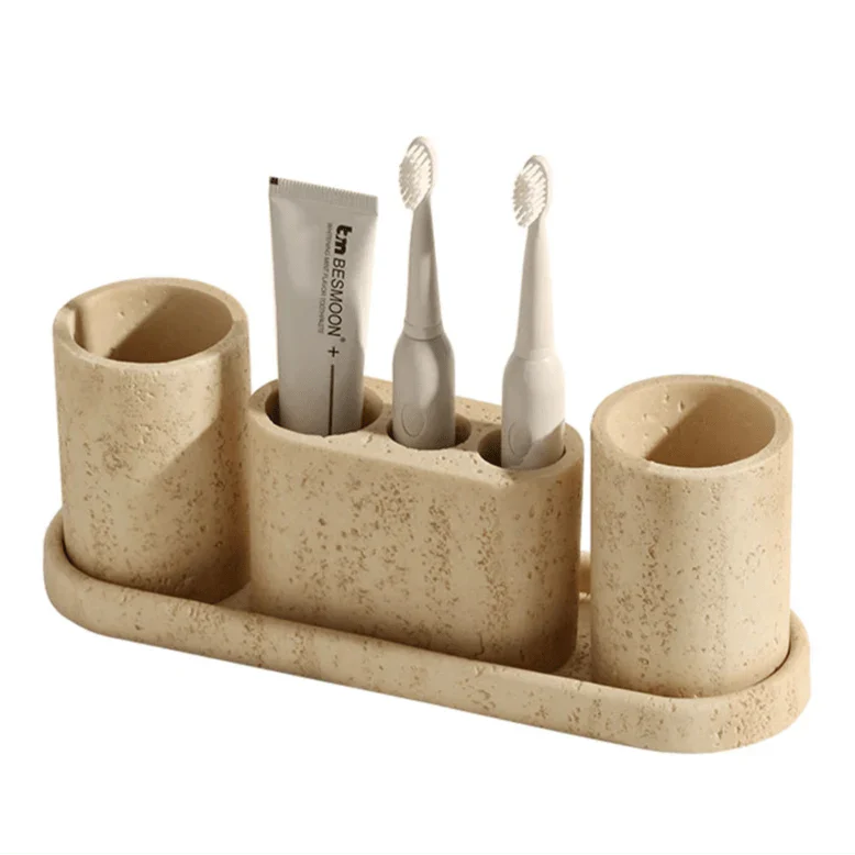 Stone effect bathroom organizer with cylindrical holders for toothbrushes and essentials.