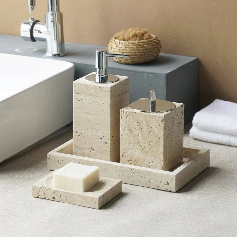 Minimalist travertine bathroom set with dispenser and holder on a countertop.