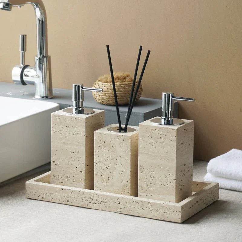 Minimalist travertine bathroom set with dispenser and holder on a countertop.