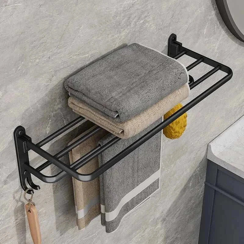 Wall-mounted MATTONIA™ towel rack with industrial iron shelf in matte black, holding folded and hanging towels in a modern bathroom.