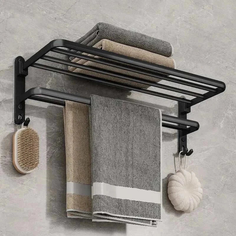 Wall-mounted matte black towel rack with upper shelf and hooks, featuring towels and accessories.