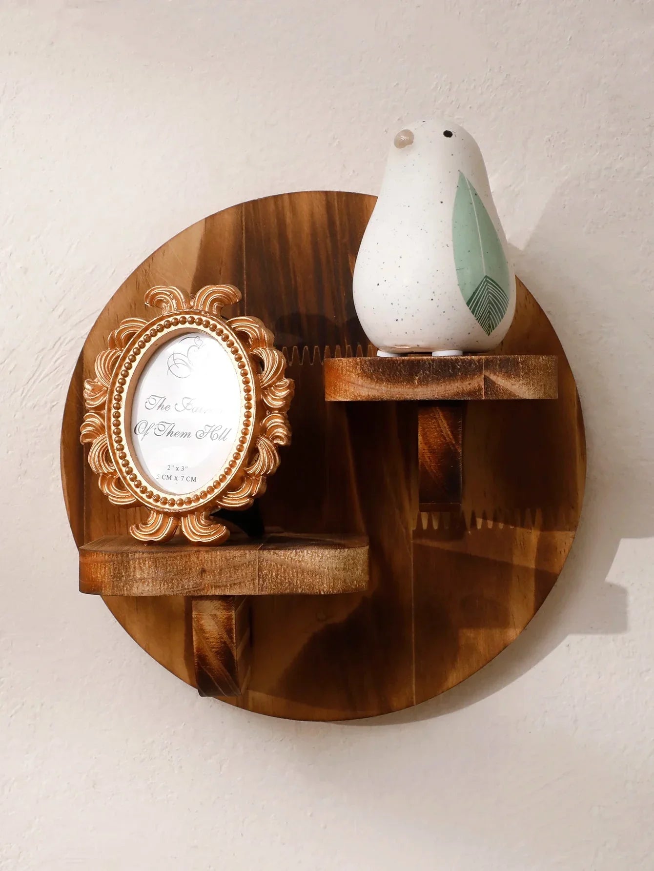 Oval floating wooden shelf set showcasing a decorative bird ornament and an ornate picture frame.