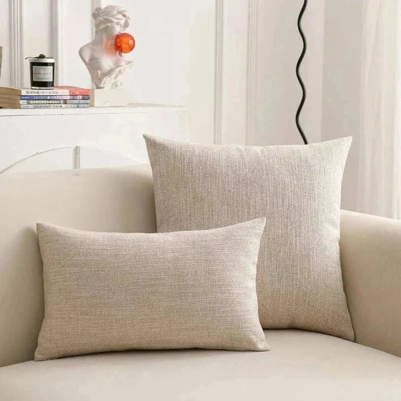 Natural linen throw pillow cover on a sofa, featuring soft, textured fabric and subtle earth tones.