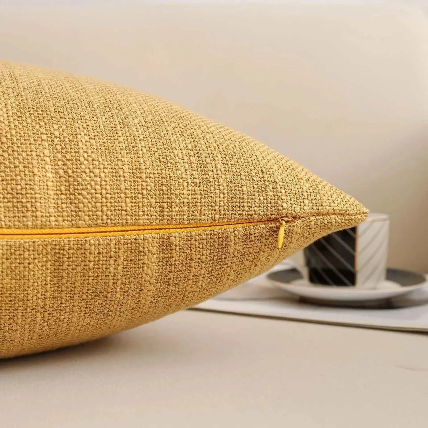 Natural linen throw pillow cover with visible weave texture and hidden metal zipper closure.