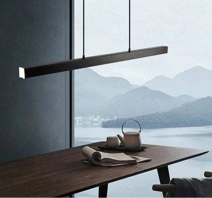 Minimal suspended LED pendant light over a kitchen table with scenic mountain view.