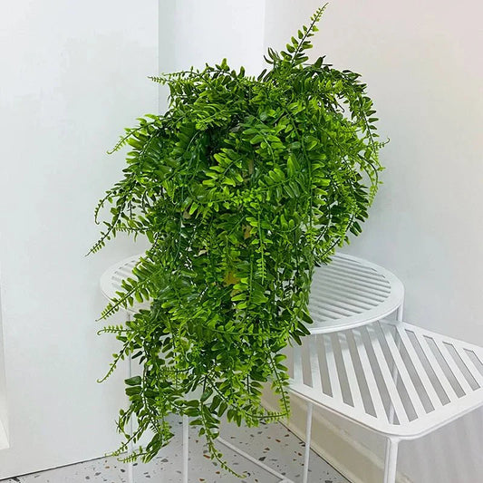 Lush faux green fern for indoor decoration on white stand.