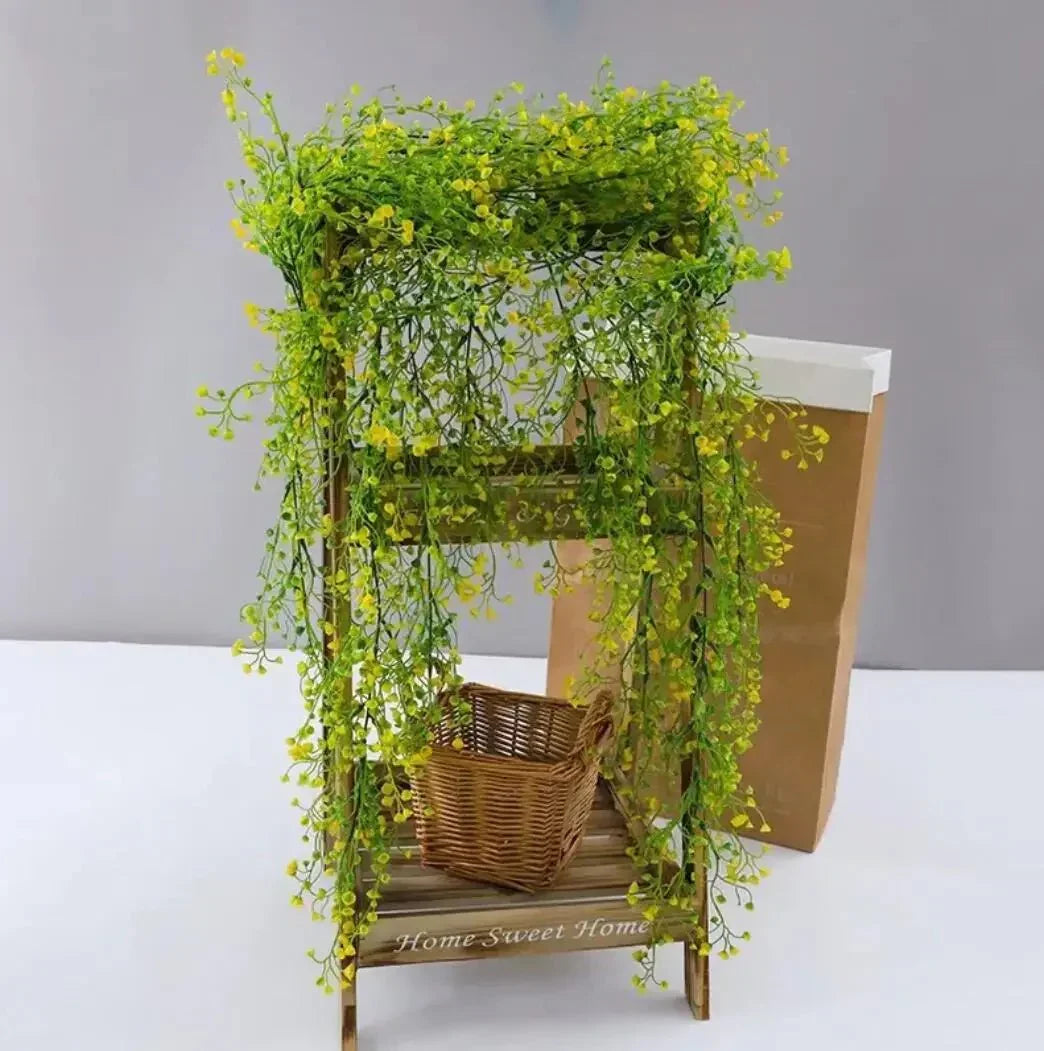 Colorful faux willow vine draping over a wooden stand with a wicker basket, showcasing vibrant green leaves.