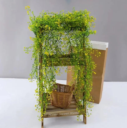 Colorful faux willow vine draping over a wooden stand with a wicker basket, showcasing vibrant green leaves.