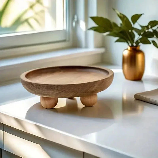 Elevated wooden tray with rounded feet on a countertop, styled with modern decor.