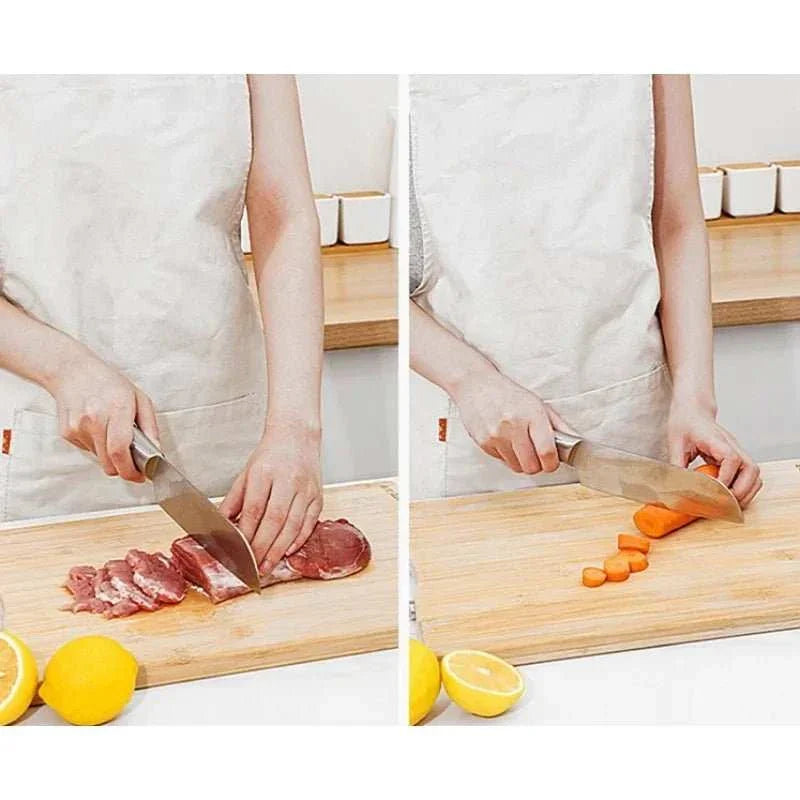 Natural bamboo cutting board with handle in use, showcasing slicing meat and carrots, featuring eco-friendly design and durability.