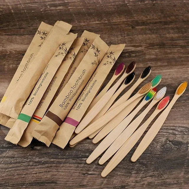 Bamboo toothbrushes and packaging on wooden surface, highlighting sustainable bathroom organizers.