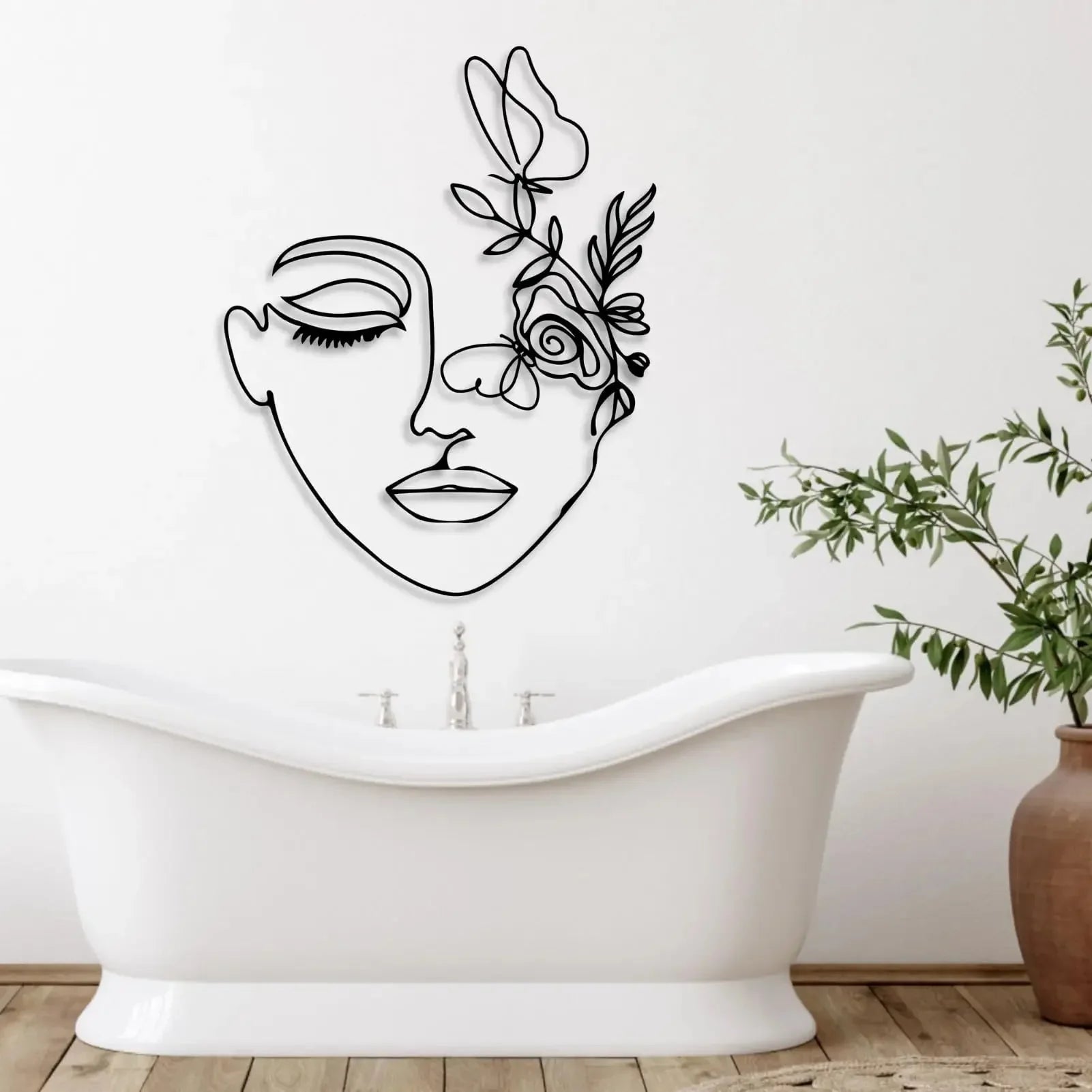Modern botanical wall art featuring feminine profile in black metal wire above a bathtub.
