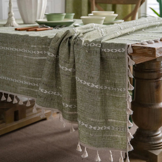 Soft linen-feel tablecloth with woven pattern and tassel edges on dining table.