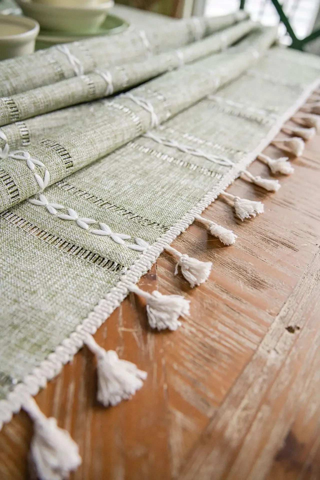 Soft linen-feel tablecloth with woven pattern and tassel edge on wooden table.