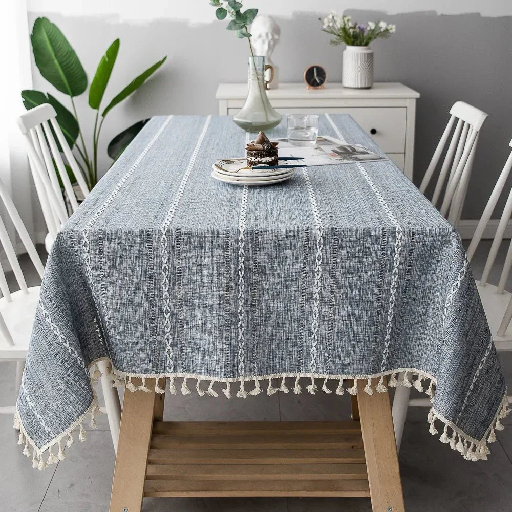 Soft linen-feel tablecloth with woven pattern and tassel edges, blending cotton and linen for durable, wrinkle-resistant use in dining spaces.