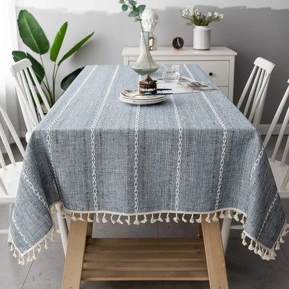 Soft linen-feel tablecloth with woven pattern and tassel edges, blending cotton and linen for durable, wrinkle-resistant use in dining spaces.