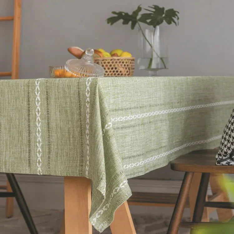 Soft linen-feel tablecloth with woven pattern and tassel edge on dining table.