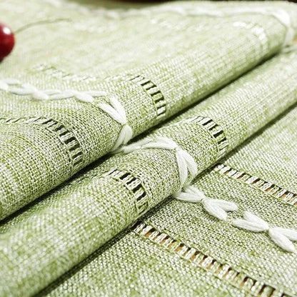 Woven natural cotton table runner with macrame embroidery in rustic farmhouse design.