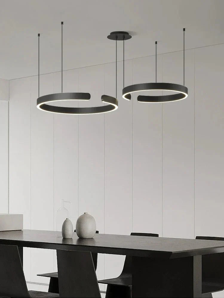 Minimalist geometric LED pendant light in a modern dining room setting.