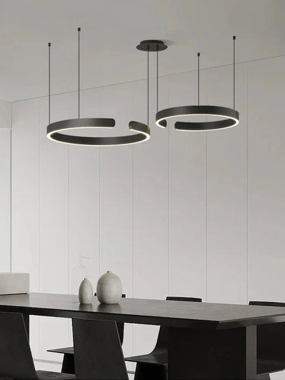 Minimalist geometric LED pendant light in a modern dining room setting.