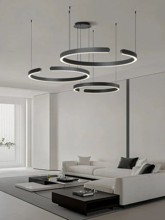 Minimalist black and white geometric LED pendant light illuminating a modern living room.