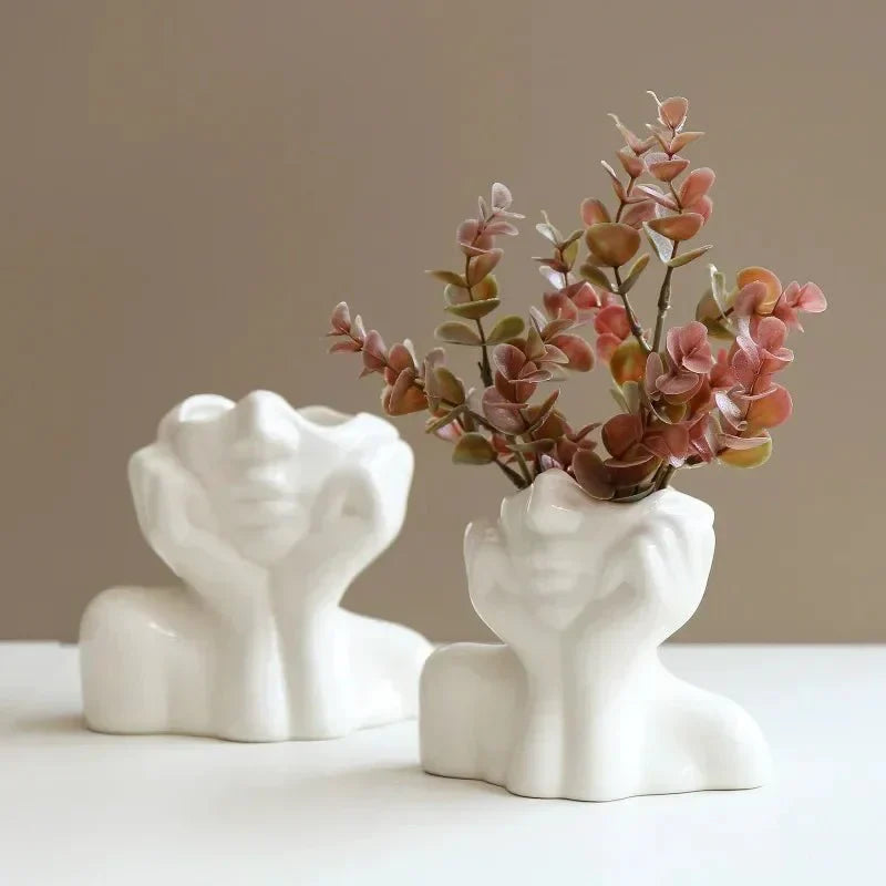 Sculptural ceramic vase with face design, perfect for single stem or decorative use.