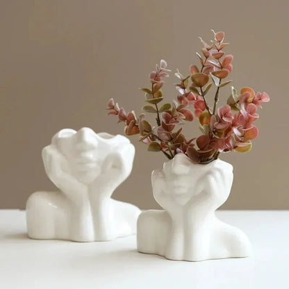 Sculptural ceramic vase with face design, perfect for single stem or decorative use.
