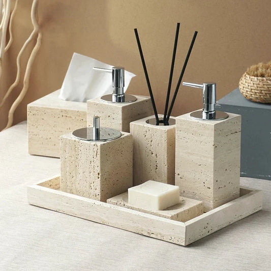 Minimalist travertine bathroom set with dispensers and holder on a tray.