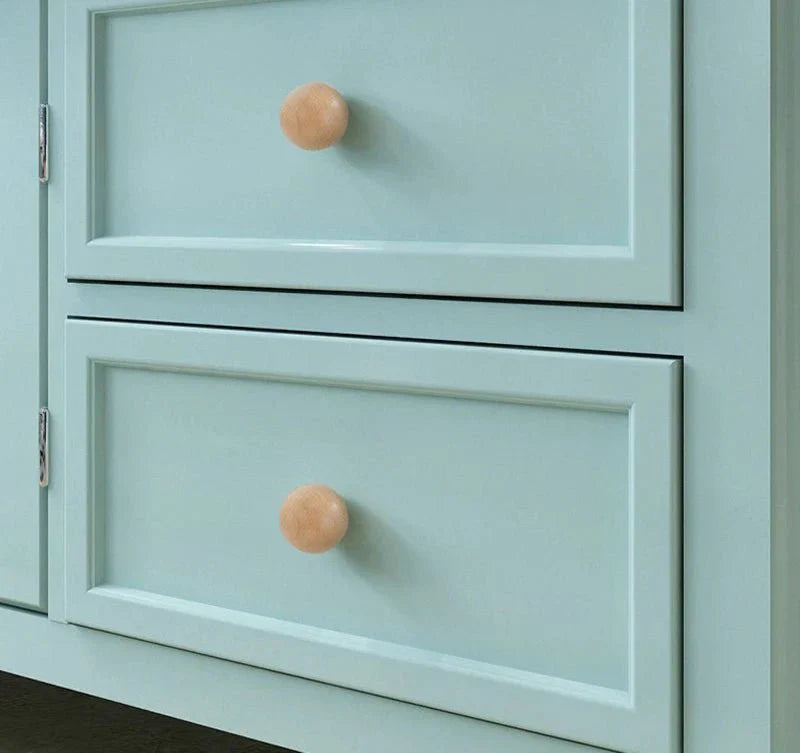 Minimalist natural wood knob on light blue drawers.