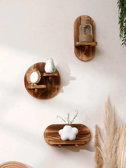 Oval and round wooden wall shelves displaying decorative items against a white wall.