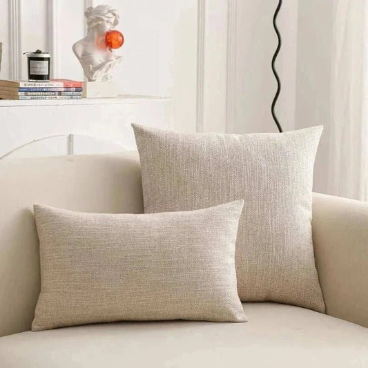 Natural linen throw pillow cover on a sofa, featuring soft, textured fabric and subtle earth tones.