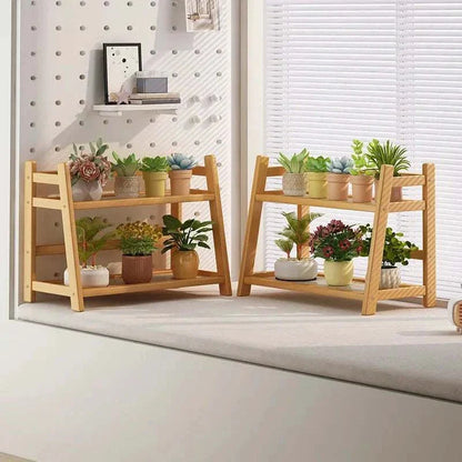 Bamboo plant stand with two tiers displaying various potted plants against a bright interior.