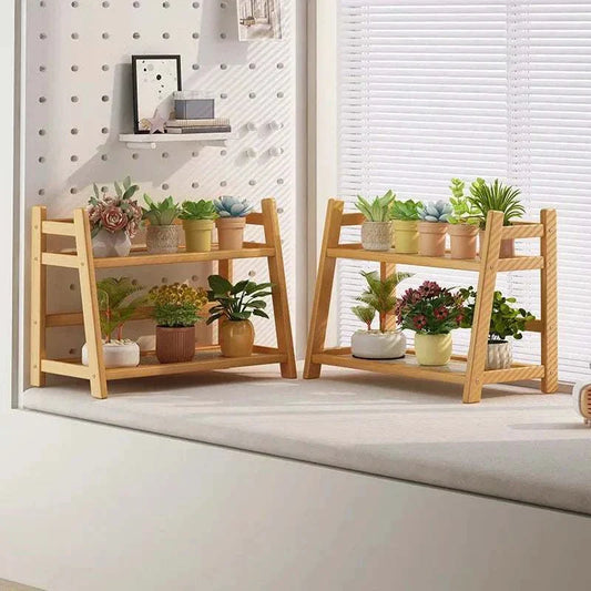Bamboo plant stand with two tiers displaying various potted plants against a bright interior.