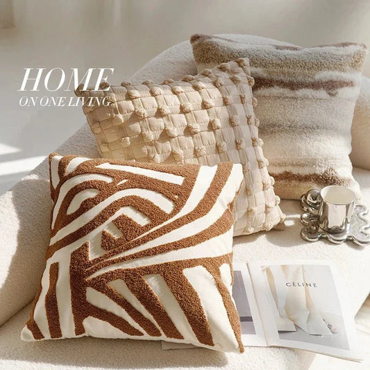 Embroidered pillow covers with earthy tones on modern decor sofa.