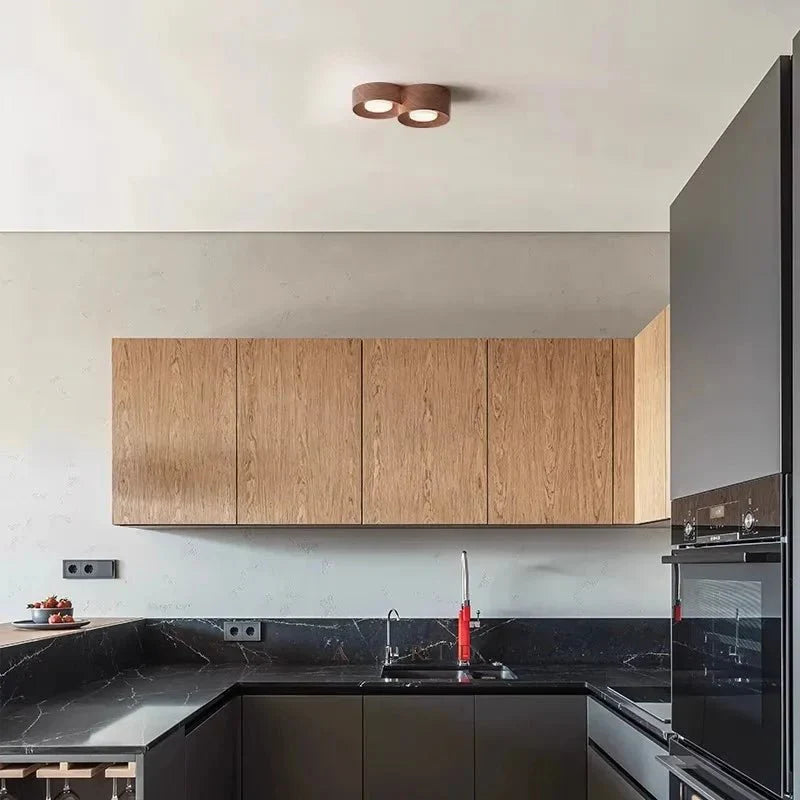 Surface-mounted walnut LED ceiling spot downlight illuminating a modern kitchen.
