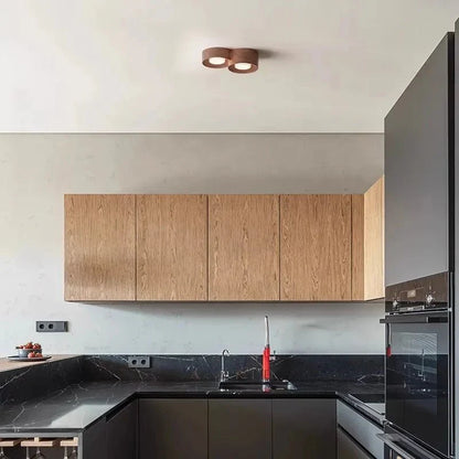 Surface-mounted walnut LED ceiling spot downlight illuminating a modern kitchen.